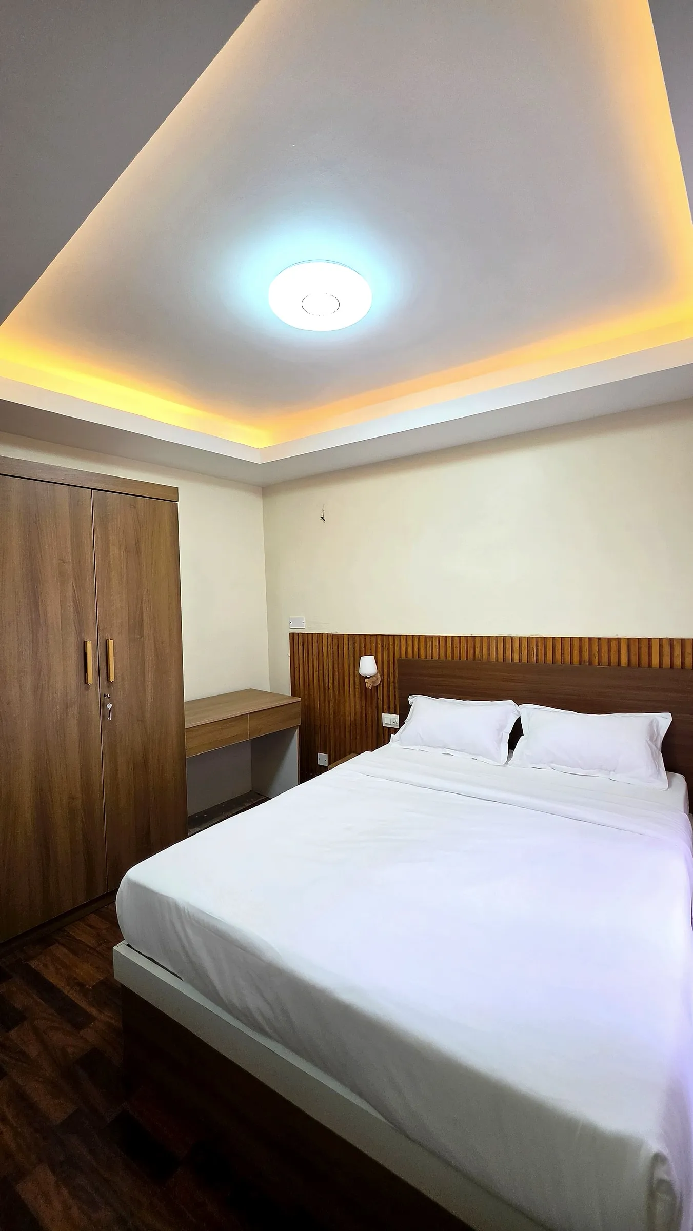 Cozy bedroom with warm ceiling lighting and wardrobe
