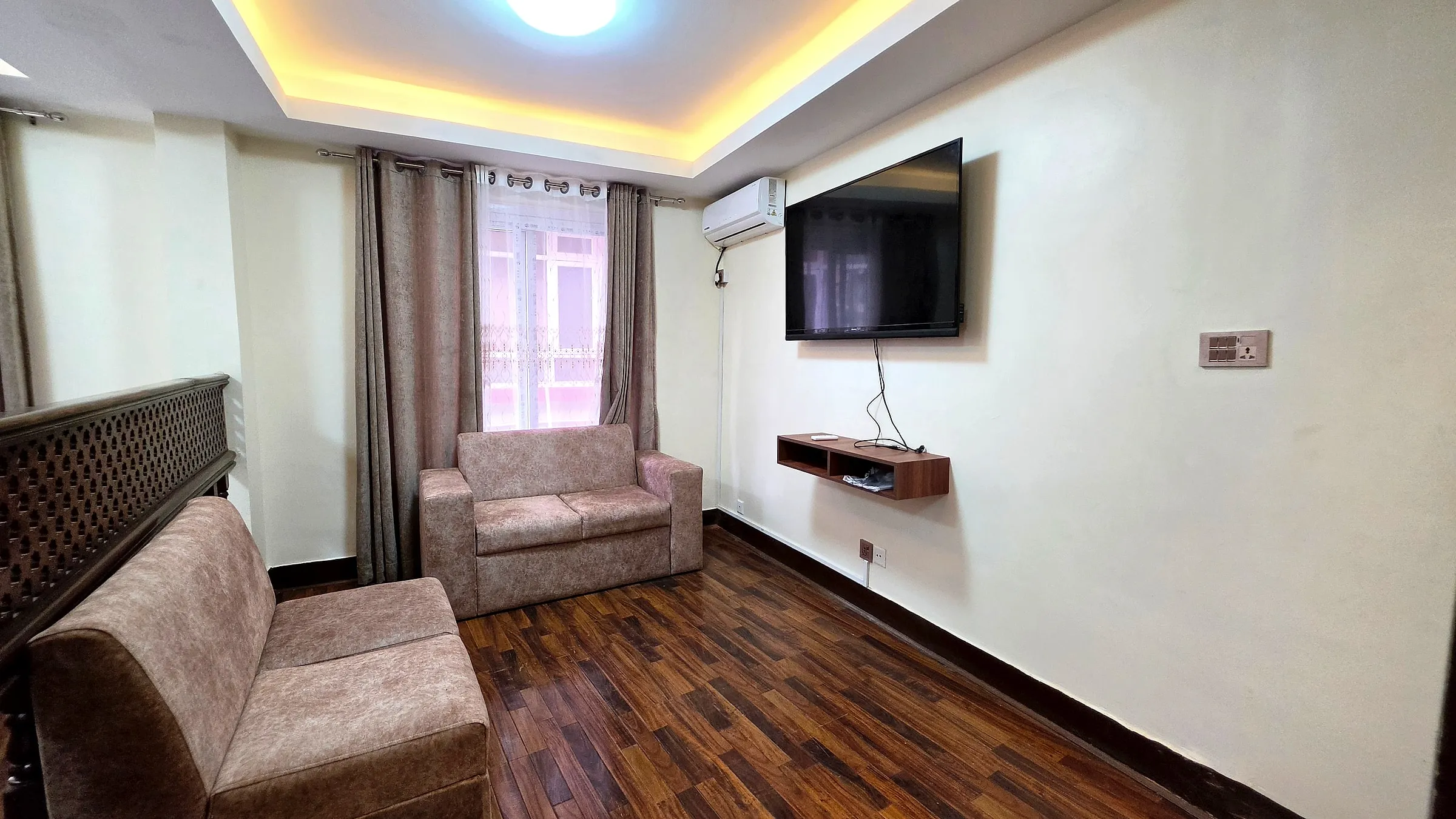 Lounge with sofas, smart TV and wood flooring